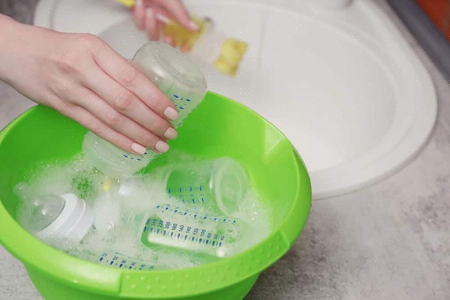 Bland to spiseskefulde opvaskemiddel i varmt vand for at skabe en løsning til skrubbekabinetter